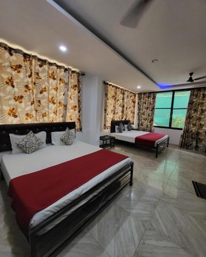 a bedroom with two beds and a large window at Hotel heaven by sky in Calangute