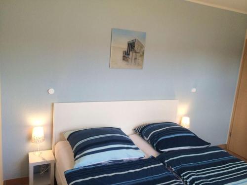 1 dormitorio con 2 camas con rayas azules y blancas en Boddensurfer 3a, en Pruchten
