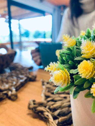 a vase filled with yellow flowers on a table at LOBOS DEL BOSQUE CON JACUZZi in Punta Del Diablo