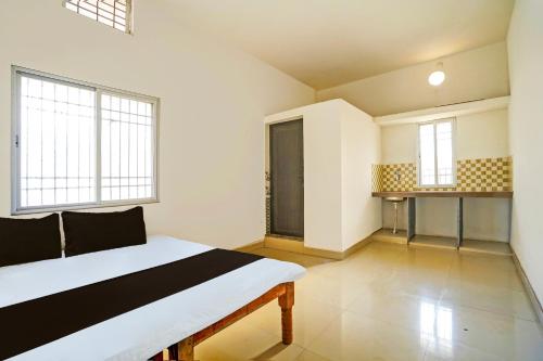 ein Schlafzimmer mit einem großen Bett und zwei Fenstern in der Unterkunft SPOT ON Hotel SB Air Port Stay in Phundardih