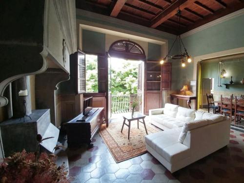 sala de estar con sofá blanco y chimenea en Historic villa near Florence, en Rignano sullʼArno