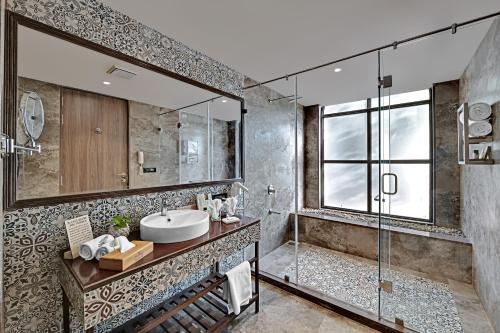 La salle de bains est pourvue d'un lavabo et d'une douche en verre. dans l'établissement Bhanu The Fern Forest Resort & Spa, Jambughoda, à Jambughoda