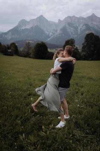 a man and a woman hugging in a field at Biohof Ebengut in Maria Alm am Steinernen Meer