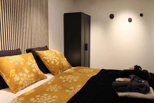 een slaapkamer met een bed met gele lakens en kussens bij B&B Kunstkamer Franeker in Franeker