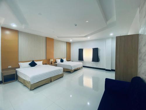 a hotel room with two beds and a television at Miền Tây Hotel in Can Tho
