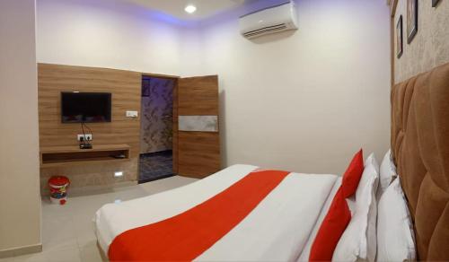 - une chambre avec un lit et une télévision dans l'établissement HOTEL LORDS IN, à Ahmedabad