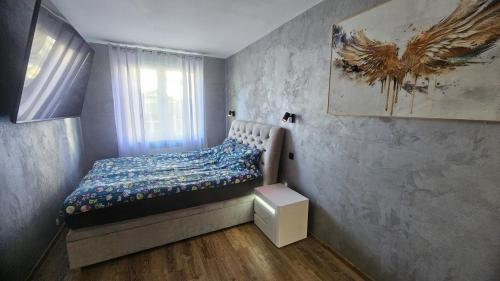 a small bedroom with a bed and a window at Apartament Słoneczna Wydma in Ustka