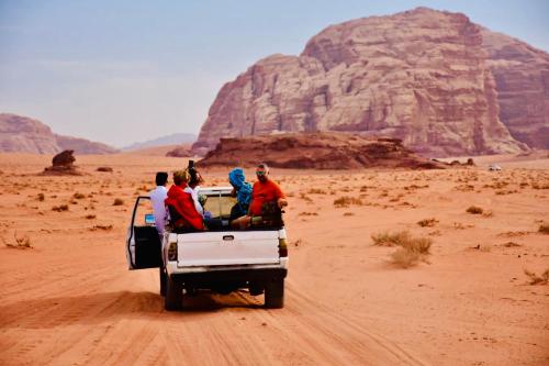 een groep mensen achterin een vrachtwagen in de woestijn bij wadi rum land mars in Wadi Rum