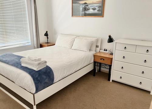 - une chambre avec un lit blanc et une commode dans l'établissement Acgated Parking North Adelaide Balcony Suite, à Adélaïde