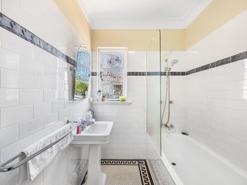 a white bathroom with a sink and a shower at Riverside Heritage Château/Convenient/Free carpark in Brisbane