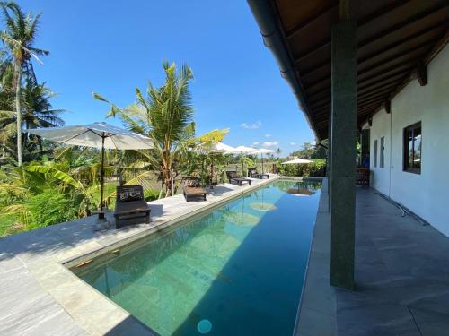 a pool at a resort with chairs and umbrellas at 4 bedroom villa aline in Marga