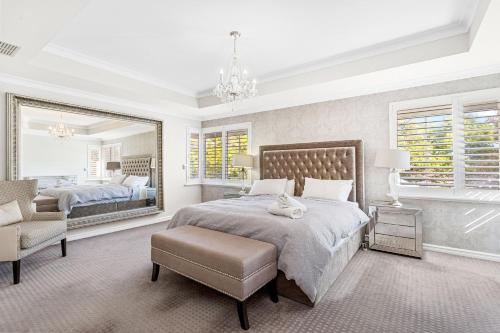een slaapkamer met een bed, een spiegel en een stoel bij 56 Picture Perfect Applecross 5br 3bth in Perth