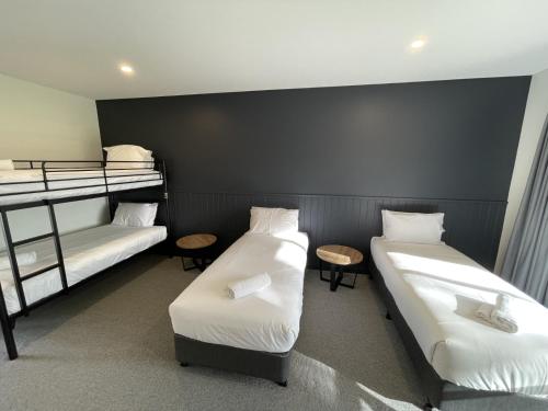 a room with two beds and two bunk beds at Harden Country Club Motel in Harden