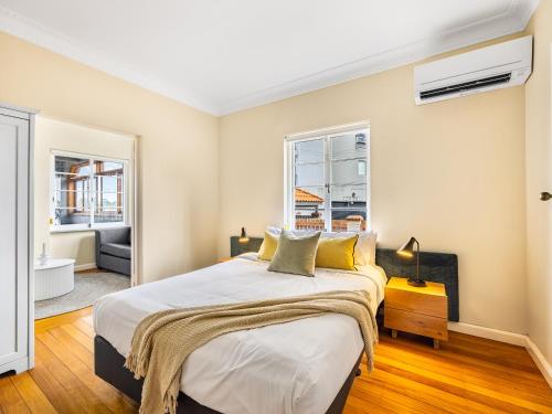 a bedroom with a large bed and two windows at Riverside Heritage Château/Convenient/Free carpark in Brisbane