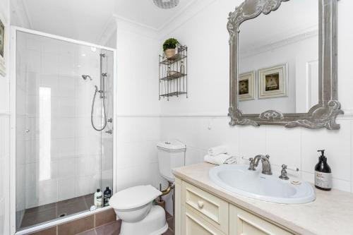 een badkamer met een toilet, een wastafel en een spiegel bij 56 Picture Perfect Applecross 5br 3bth in Perth