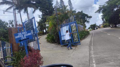a man standing in a gate on the side of a street at Island Skyview Resort - JVR by Hiverooms in Balamban