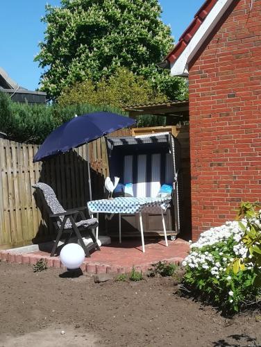 a patio with a table and a chair and an umbrella at Ferienwohnung Arff in Rendsburg