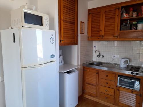 une cuisine avec un réfrigérateur blanc et un évier dans l'établissement apartment for couples 257, à Arenal d'en Castell
