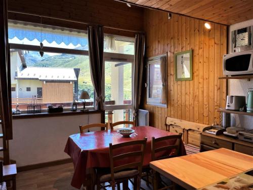 une salle à manger avec une table et une fenêtre dans l'établissement Résidence Asters - Appartement chaleureux avec mezzanine et cuisine équipée MAE-4484, aux Menuires