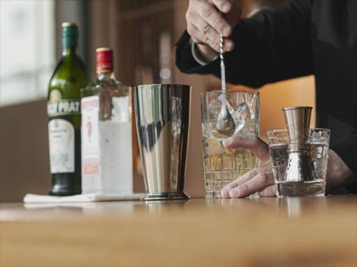 a person is stirring a drink in a glass at Okinawa EXES Naha in Naha