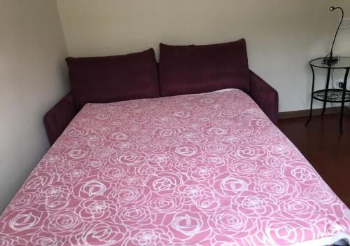 Una cama con una manta rosa encima. en La Dolce Vita Bedrooms Near the Subway, en Roma