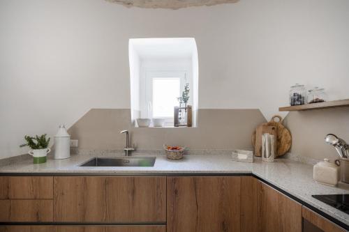 a kitchen counter with a sink and a window at Trulli del Minareto in Selva di Fasano