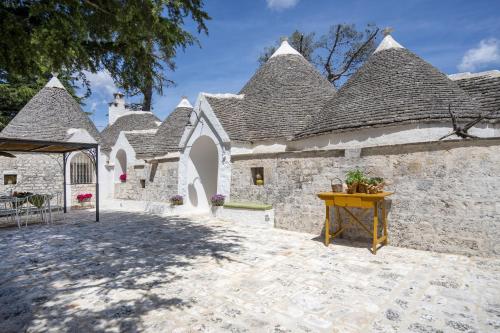 a stone building with a table in front of it at Trulli del Minareto in Selva di Fasano