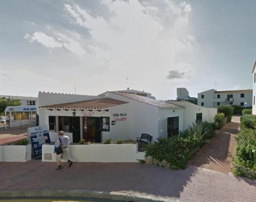 un homme marchant devant un bâtiment blanc dans l'établissement apartment for couples 257, à Arenal d'en Castell