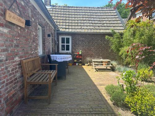 a patio with a bench and a brick building at Op den Distelberg in Helvoirt