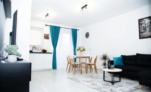 a living room with a black couch and a table at Milan Luxury Apartaments II-Maurer Residence in Târgu-Mureş