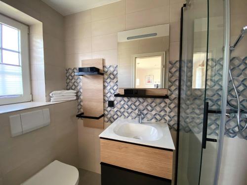 a bathroom with a sink and a shower at Sylvie Steinhardt, Wohnung 3 in List