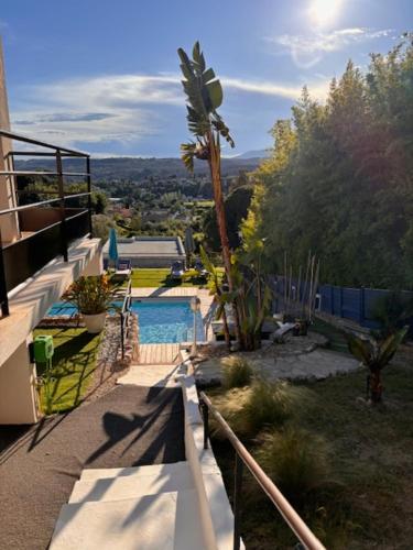 vistas a una piscina con palmeras en Chambre d'hôtes Le Clos 67, en Saint-Paul-de-Vence