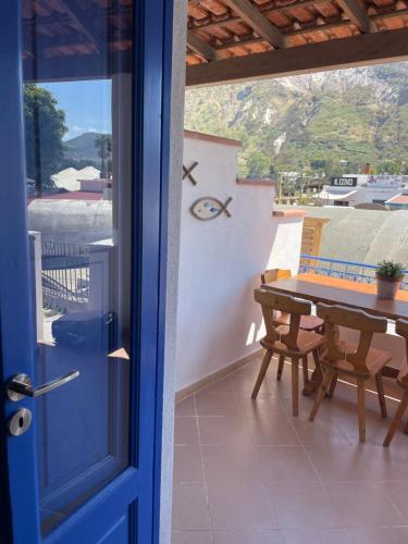 a door to a balcony with a table and chairs at Casa Claire in Vulcano