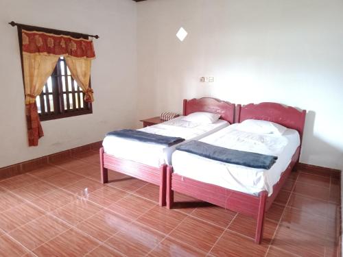 1 dormitorio con cama y ventana en Harus Damai Inn, en Lagudri