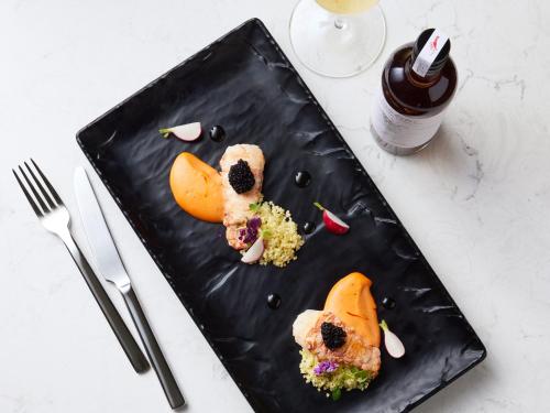 a black plate with food on a table at PARKROYAL Melbourne Airport in Melbourne