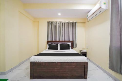 a bedroom with a bed and a window at OYO Hotel Bluebird Inn in Nagpur