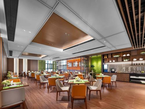 una sala da pranzo con tavoli e sedie in un ristorante di Hampton by Hilton Wuhan Zhongnan Jiedaokou Hotel a Wuhan