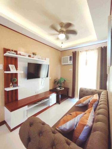 uma sala de estar com um sofá e uma televisão de ecrã plano em Palawan Paradise Condotel 2B em Puerto Princesa
