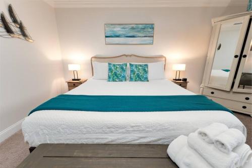 a bedroom with a large bed with towels on it at Be A Nomad - 1 blk to beach - Stylish studio in Jacksonville Beach