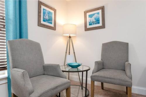 two chairs and a table and a lamp in a room at Be A Nomad - 1 blk to beach - Stylish studio in Jacksonville Beach