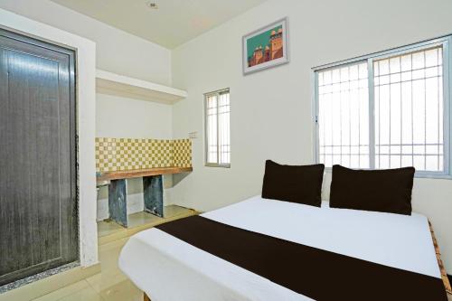 sypialnia z białym łóżkiem i kominkiem w obiekcie SPOT ON Hotel SB Air Port Stay w mieście Phundardih