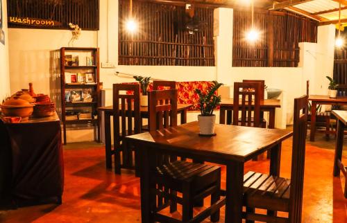 a dining room with a wooden table and chairs at Surfers Park Arugambay in Arugam Bay