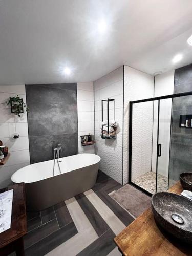 une grande salle de bain avec baignoire et douche dans l'établissement Maison de Campagne, à Saint-Cyr-du-Ronceray