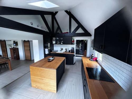 une cuisine avec un comptoir en bois dans une pièce dans l'établissement Maison de Campagne, à Saint-Cyr-du-Ronceray