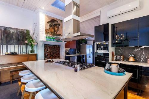 a large kitchen with a large island with stools at STUNNING TROPICAL OASIS free parking in Brisbane