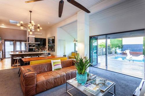 a living room with a brown couch and a table at STUNNING TROPICAL OASIS free parking in Brisbane