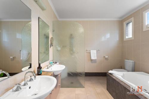 a bathroom with two sinks and a shower and a toilet at Spacious Retreat with Coastal Views in Cowes