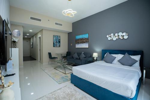 a bedroom with a blue bed and a living room at Escape24 Studio at Loreto with Community View in Dubai