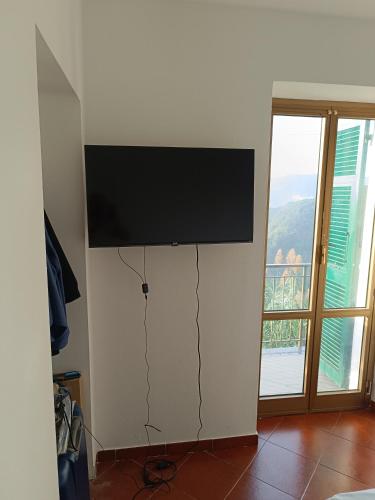 een flatscreen-tv aan een muur bij A mezz'ora da Genova e dal Mare in Tasso