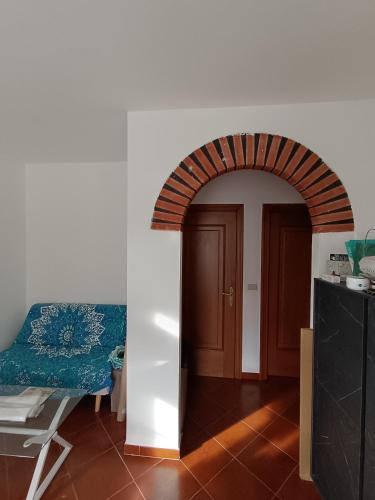 een boog die leidt naar een kamer met een tafel en een deur bij A mezz'ora da Genova e dal Mare in Tasso